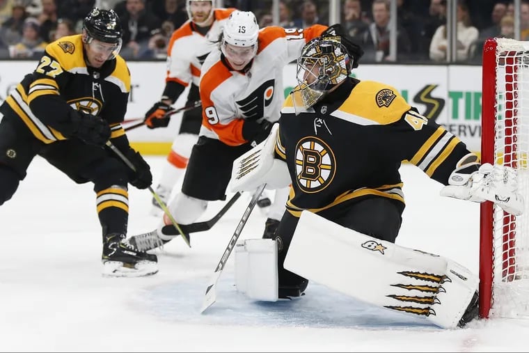 Boston's John Moore (27) and the Flyers'  Nolan Patrick (19) battle for the puck in front of Bruins goalie Jaroslav Halak on Thursday. Halak blanked the Flyers, 3-0.