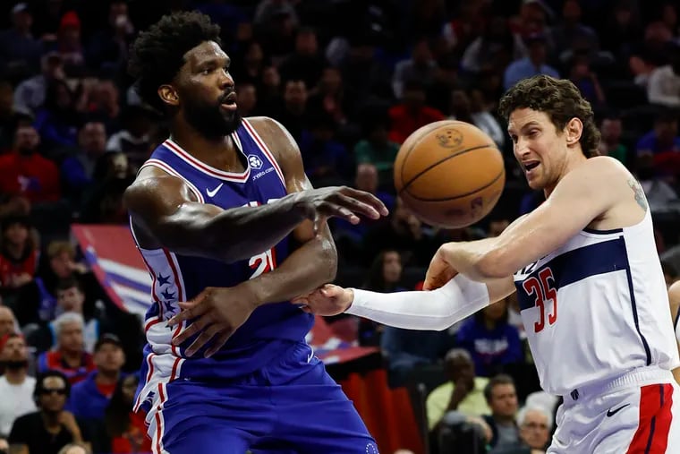 Sixers center Joel Embiid passes the basketball against Washington Wizards center Mike Muscala on Nov. 6.