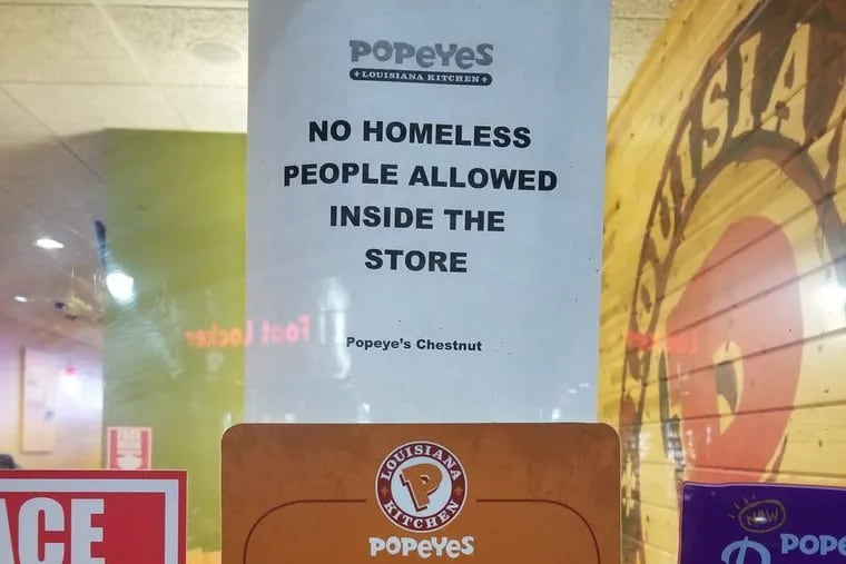 A sign declaring "no homeless people allowed" posted in the front window of the Popeyes on Chestnut Street near 15th Street sparked controversy on social media.
