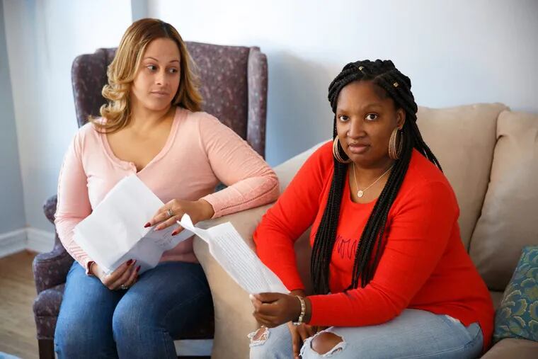 Gladys Cruz (left) and Ayana Reel at Cruz’s home in Holme Circle. They are holding paperwork from their court hearings against travel agent Stephanie Mountcastle-Claiborne, who they claim scammed them.
