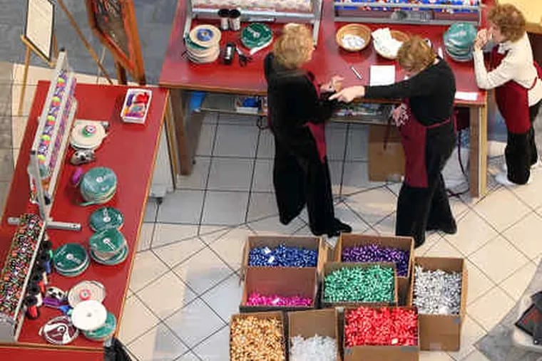 Volunteers from the Marlyn Fein chapter of the Fox Chase Cancer Center wrap gifts for donations at the Willow Grove Park Mall on Wednesday.