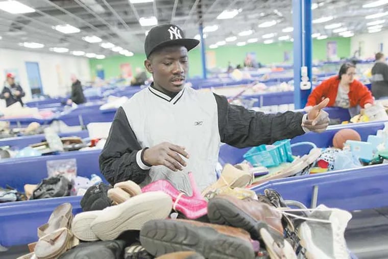 Mohamed Fornah purchased 150 pounds of shoes that he will ship to Sierra Leone. Goodwill had a grand opening of their Bellmawr store where customers can sort through bins and pay 98 cents per pound for items. March 5, 2013. ( MICHAEL S. WIRTZ / Staff Photographer ).