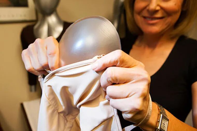Debra Kimless-Garber inserts a Breast Shaper into one of her mastectomy bras. ED HILLE / Staff Photographer