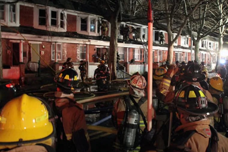 Firefighters work to extinguish a four-alarm fire which spread to entire block of row homes on West Philadelphia Ave., in Morrisville Pa., Saturday Feb. 25, 2012. (Joseph Kaczmarek)