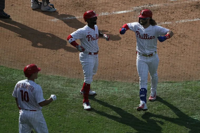 Phillies OF Bryce Harper celebrates with teammates Andrew McCutchen (22) and J.T. Realmuto (10) after a home run in the third inning.