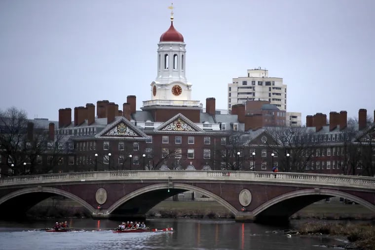 Rowers paddle down the Charles River past the campus of Harvard University in Cambridge, Mass. A lawsuit alleging racial discrimination against Asian American applicants in Harvard's admissions process is heading to trial in Boston's federal court on Monday, Oct. 15, 2018.
