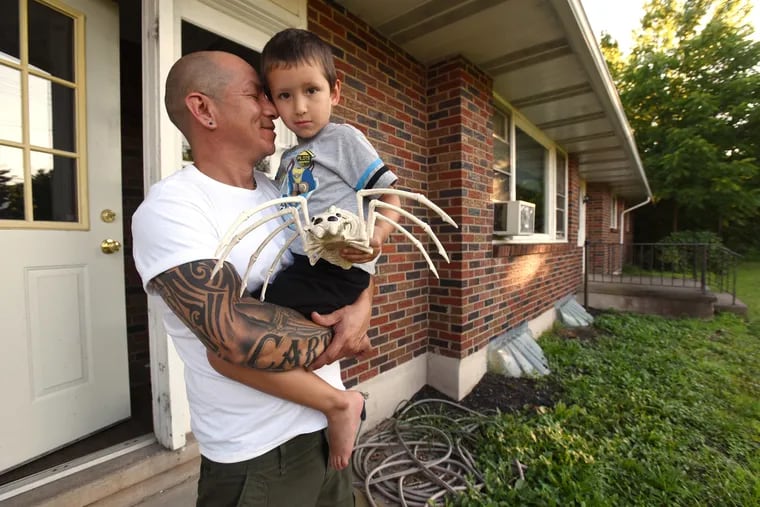Carlos Diaz, left, is shown holding his son Carter Diaz, right, at his home in Quakertown.