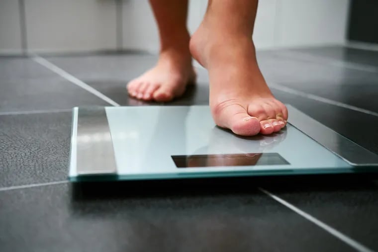 Bare feet with weight scale in the bathroom