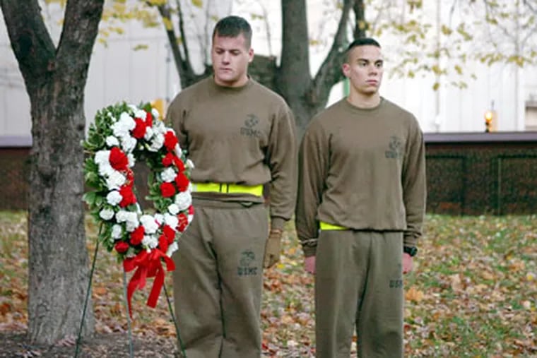 Ryan Carey (left) and Patrick Fullbright stand silently next to the wreath left to honor Samuel Nicholas, the founder of the Marine Corps. A group of 40 ROTC cadets from Villanova and Penn appeared at first light to celebrate the Corps' founding day in Philadelphia. (Sarah J. Glover / Staff Photographer)