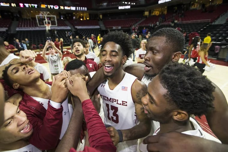 Temple players, including Quinton Rose (center), celebrate after their victory over St. Joseph’s.