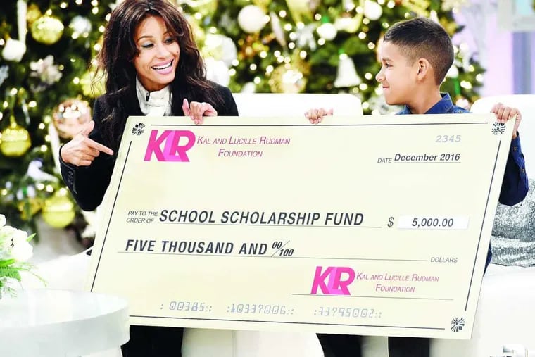 Kimberly Moore of the Kimberly Moore Foundation presents the Kal and Lucille Rudman check to 9-year old Francisco on the holiday episode of &#039;The Doctors,&#039; seen locally on CBS3.