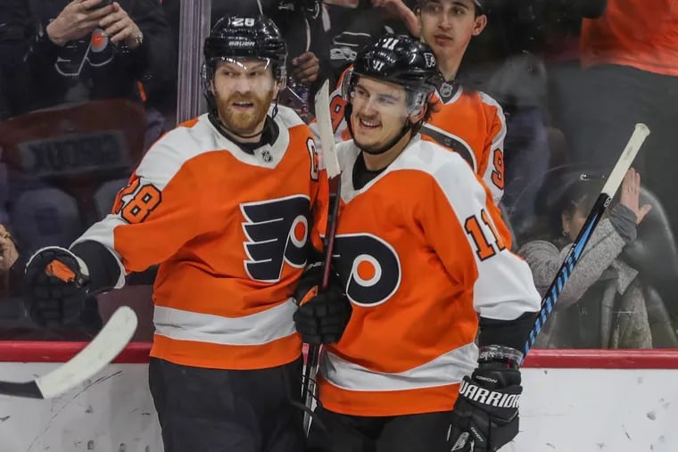 Claude Giroux (left) is congratulated by teammate Travis Konecny after Giroux scored the game’s first goal in the Flyers’ 4-3 overtime win Sunday over Boston.
