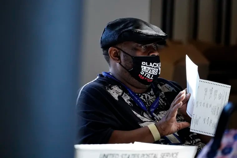 An election worker holds a ballot while counting votes at State Farm Arena in Atlanta last month.