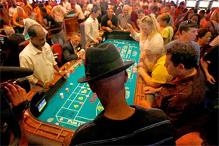 Patrons around a craps table on the crowded floor of the SugarHouse Casino on North Delaware Avenue. Legislators have proposed moving the city's second casino license elsewhere in the state. (David Maialetti / Staff Photographer)