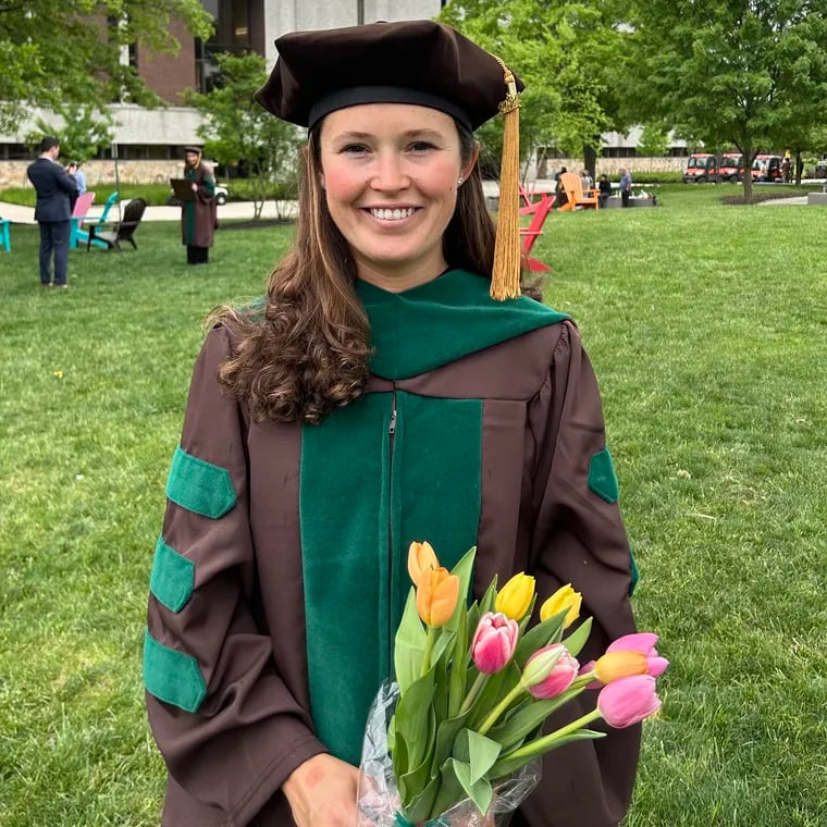 Keri Cronin holds a bouquet of flowers after graduating from Cooper Medical School of Rowan University in Camden, N.J., earlier this month. Cronin was diagnosed with Stage 4 cancer in 2021. Now in remission, she is on the path to becoming an oncologist.