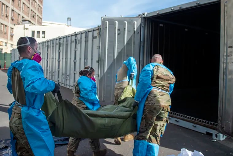 National Guard members assisting with processing COVID-19 deaths, placing them into temporary storage at the medical examiner-coroner's office in Los Angeles.