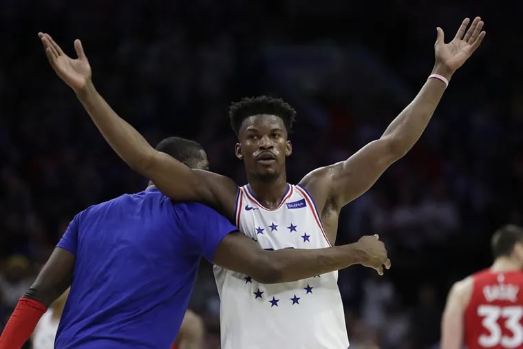 Sixers guard Jimmy Butler raises his arms with teammate forward James Ennis III after Butler made a basket late in the first-half against the Toronto Raptors during the Eastern Conference playoff semifinals on Thursday, May 9.