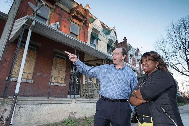 Outside the Belfield Avenue house are Ken Weinstein, who helps train developers, and Tiffany Tull, one of the earliest participants in the Jumpstart Germantown program.