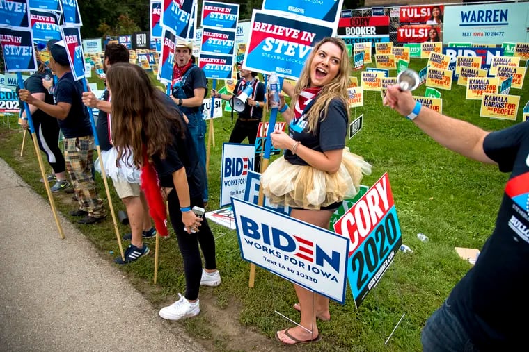 Volunteer Riley Nelson from Colorado Springs supporting Gov. Steven Bullock of Montana greets voters arriving at the Polk County Steak Fry, a huge gathering of Democrats in Des Moines, Iowa, on Sept. 21, 2019.