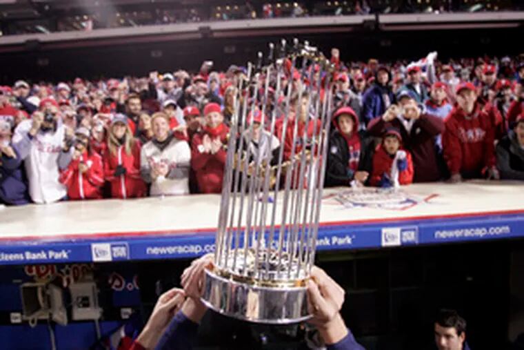 Phillies hold Commissioner&#0039;s Trophy after winning World Series last night.