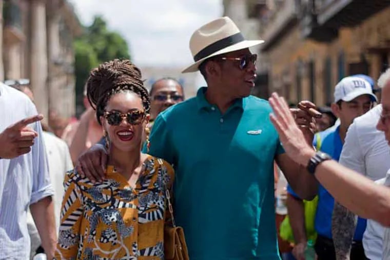 U.S. singer Beyonce and her husband, rapper Jay-Z, right, tour Old Havana as they walk with body guards and a tour guide in Cuba, Thursday, April 4, 2013. R&B's power couple is in Havana on their fifth wedding anniversary. (AP Photo/Ramon Espinosa)