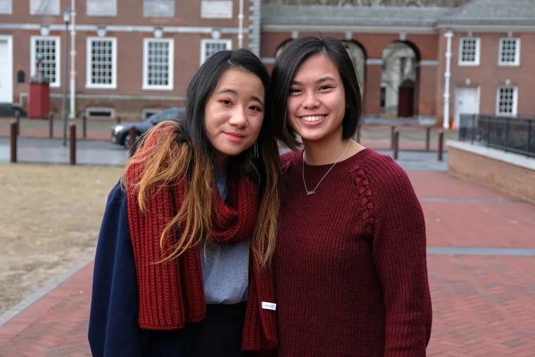 Bryn Mawr College student Claire Mitchell, 20, (left) and Temple University student Stefanie Beard, 21, in front of Independence Hall at 6th and Chestnut Street on Friday morning. Both women were adopted from Huazhou Social Welfare Institution in Southern China and discovered after a 23andMe DNA test that they were related .