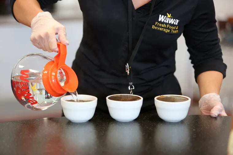 Rachel Toner, part of the Fresh Food and Beverage Team, pours boiling water into small cups of coffee grains during a procedure called "cupping" to test for the consistency and quality control of Wawa coffee at Wawa Corporate Headquarters in Media, Pa.