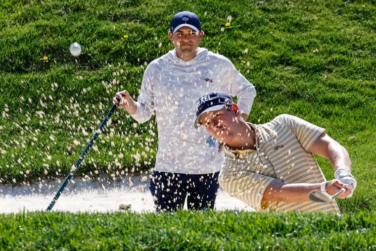 Drexel golf coach Ben Feld working with Oscar Maxfield in the sand trap at Green Valley Country Club in Lafayette Hill, Monday, April 15, 2024.
