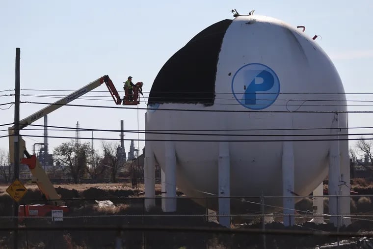 Workers disassemble butane tanks in the north yard of the former Philadelphia Energy Solutions refinery in South Philadelphia in November 2020. The PES site was purchased by Hilco Redevelopment Partners, which plans to demolish the refinery and build a set of warehouses in its place. Hilco is redeveloping the property, while a subsidiary of former owner Sunoco remains responsible for cleaning up contamination that occurred until 2012.