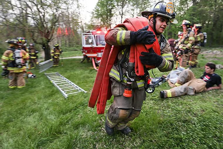 Firefighter Nat Vazquez runs with a hose line during a drill with members of the Keystone Valley Fire Department in Parkesburg, Pa. (  Steven M. Falk / Staff Photographer )