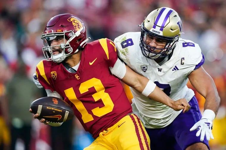 USC quarterback Caleb Williams, left, gets away from Washington defensive end Bralen Trice. The Southern Cal QB is expected to go first overall in the 2024 NFL draft.