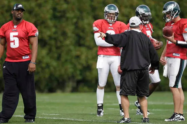 Eagles quarterbacks coach James Urban talks with Kevin Kolb (right), who was joined by (from left) Donovan McNabb, Jeff Garcia, and Michael Vick.