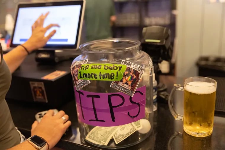 At Fat Lady Brewing Company, a customer leaves a credit card tip. The bar also accepts cash tips.