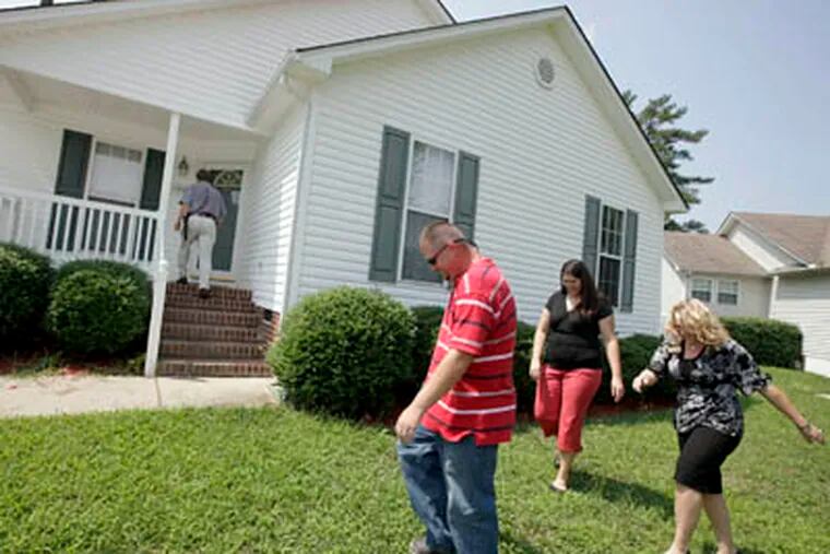 Jeremy and Shannon Wallace, center, first-time home buyers, do a walkthrough on an eleven-year-old house with a home inspector Bill Delamar, on porch in background, and their broker Kristal Eichar, far right, August 5, 2009, in the Emerald Pointe subdivision in Knightdale, North Carolina. (Shawn Rocco / Raleigh News & Observer / MCT)