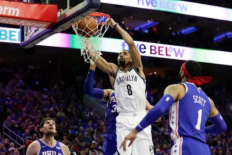 Spencer Dinwiddie dunks past Boban Marjanovic, Tobias Harris and Mike Scott during the Sixers' loss to the Nets on Saturday.