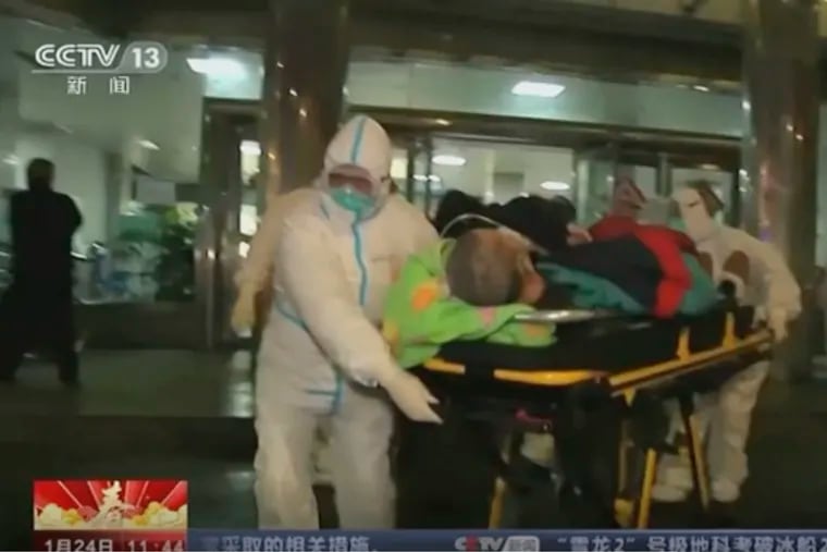 Image from China's CCTV video, a patient is carried on a stretcher to an ambulance by medical workers in protective suits in Wuhan, China. China is swiftly building a hospital dedicated to treating patients infected with a new virus that sickened hundreds and prompted unprecedented lockdowns of cities home to millions of people during the country's most important holiday.