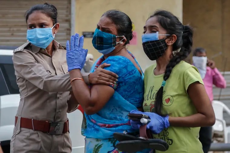 Relatives of a patient who died of COVID-19 mourn outside a government COVID-19 hospital in Ahmedabad, India, on Tuesday. The COVID-19 death toll in India has topped 200,000 as the country endures its darkest chapter of the pandemic yet.