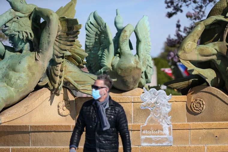 Peter Slavin, owner of Ice Sculpture Philly, walks away after placing his unicorn ice sculpture on the fountain at Logan Square on Sunday.
