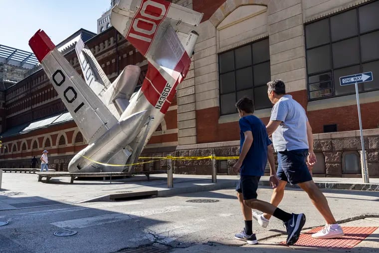 Pedestrians walking along Cherry Street at Carlisle. Sculpture Grumman Greenhouse by Jordan Griska is being removed in mid-August from its spot next to PAFA.
