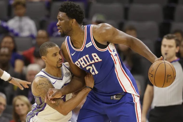 Kings guard George Hill  tries to stop 76ers center Joel Embiid during the first quarter.