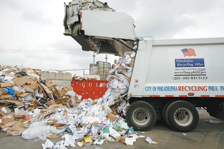 A recycling truck dumps its load at Blue Mountain Recycling, where materials are sorted and prepared for sale. (Eric Mencher / Staff Photographer)