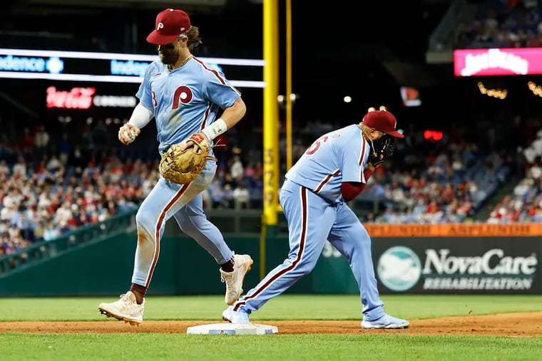 Phillies first baseman Bryce Harper steps over first base for the final out of the 11th inning as pitcher Jose Alvarado yells into his glove after the Mets scored two runs in the extra inning.