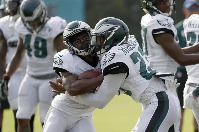 The  Eagles’ Rodney McLeod (right) makes contact with Jomal Wiltz  in a drill on Thursday.