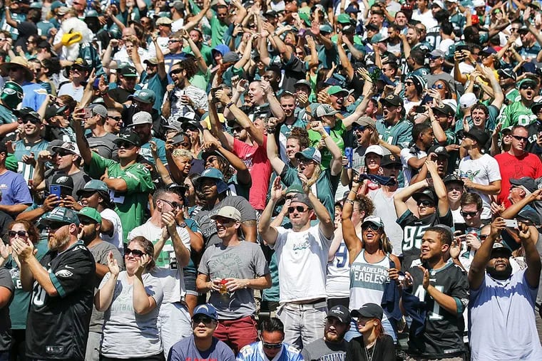 Happy Eagles fan cheer after their team scored a touchdown against the Chargers.