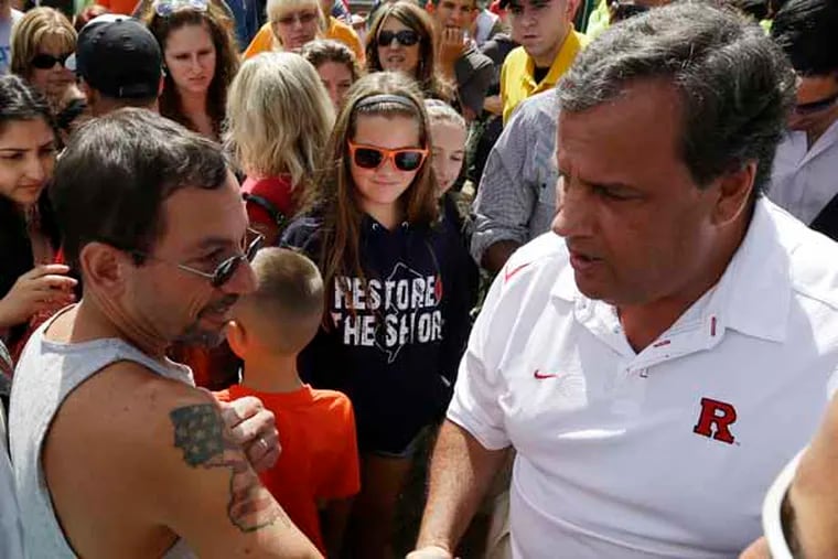 Pete Bachella of Ringwood, N.J., displays his New Jersey map tattoo to New Jersey Gov. Chris Christie during a visit Saturday to the Seaside Park boardwalk two days after a massive fire burned a large portion of the boardwalk. (AP Photo/Julio Cortez)