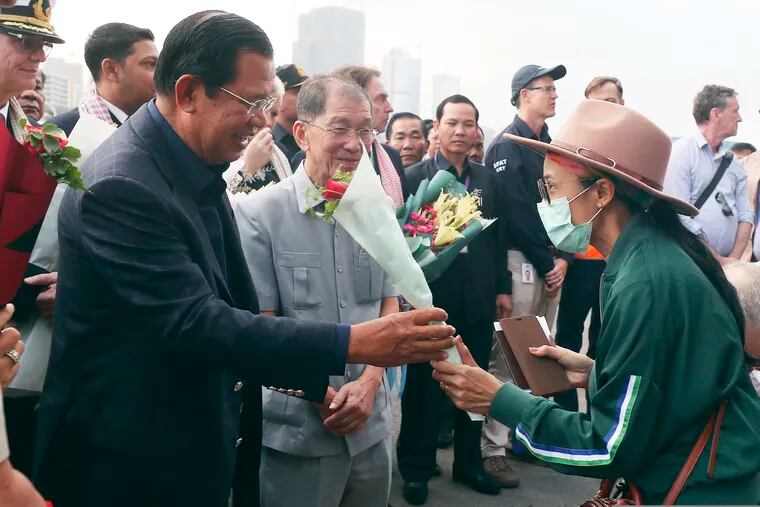 Cambodia's Prime Minister Hun Sen gives a bouquet of flowers to a passenger who disembarked from the MS Westerdam, owned by Holland America Line, at the port of Sihanoukville, Cambodia on Friday.