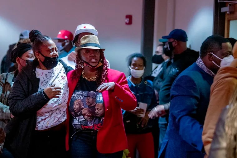The family of Walter Wallace Jr. leaves a community meeting at the Church of the Christian Compassion in Cobbs Creek on Tuesday while State Sen. Anthony Williams shows a police body cam video of a white person being shot. The video was not from the Wallace shooting, but one Williams said community members asked him to play to show a police “double standard."