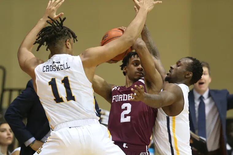 Ed Croswell, left, and David Beatty of La Salle  trap Jalen Cobb of Fordham during the 1st half on Feb. 19, 2020.