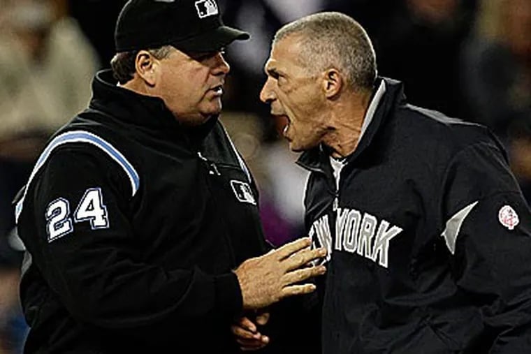 Yankees manager Joe Girardi argues with umpire Bob Davidson on Saturday. (Paul Sancya/AP)