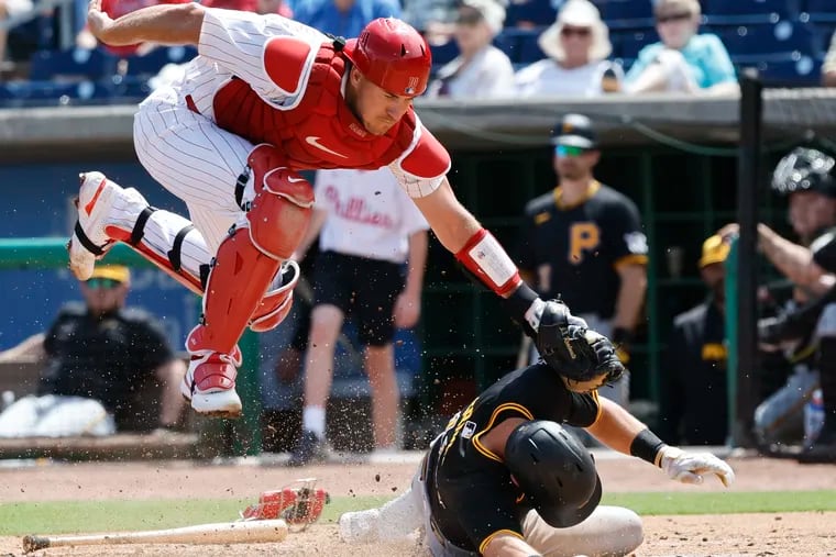 Phillies catcher J.T. Realmuto leaps past Pirates Jared Triolo in the second inning.  Triolo was safe on the play.